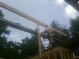 Carpenter setting a ridge beam over a new addition frame — Ice Dam Removal by Roofing Brothers in Saint Johnsville