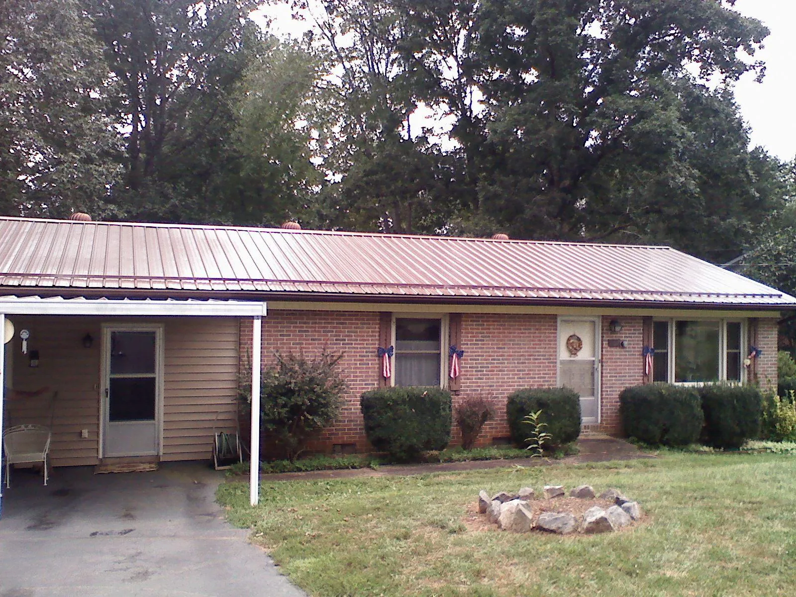 Bronze metal roof and carport on a brick ranch home — Roof Repair work by our crew in Saint Johnsville